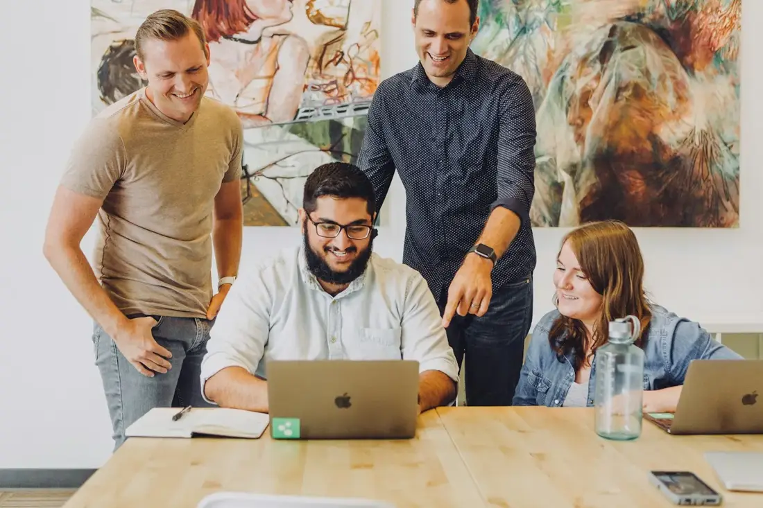 A growing team working together around a laptop