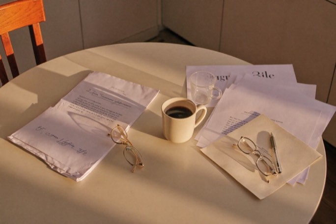 Household paperwork and coffee on a kitchen table in morning light