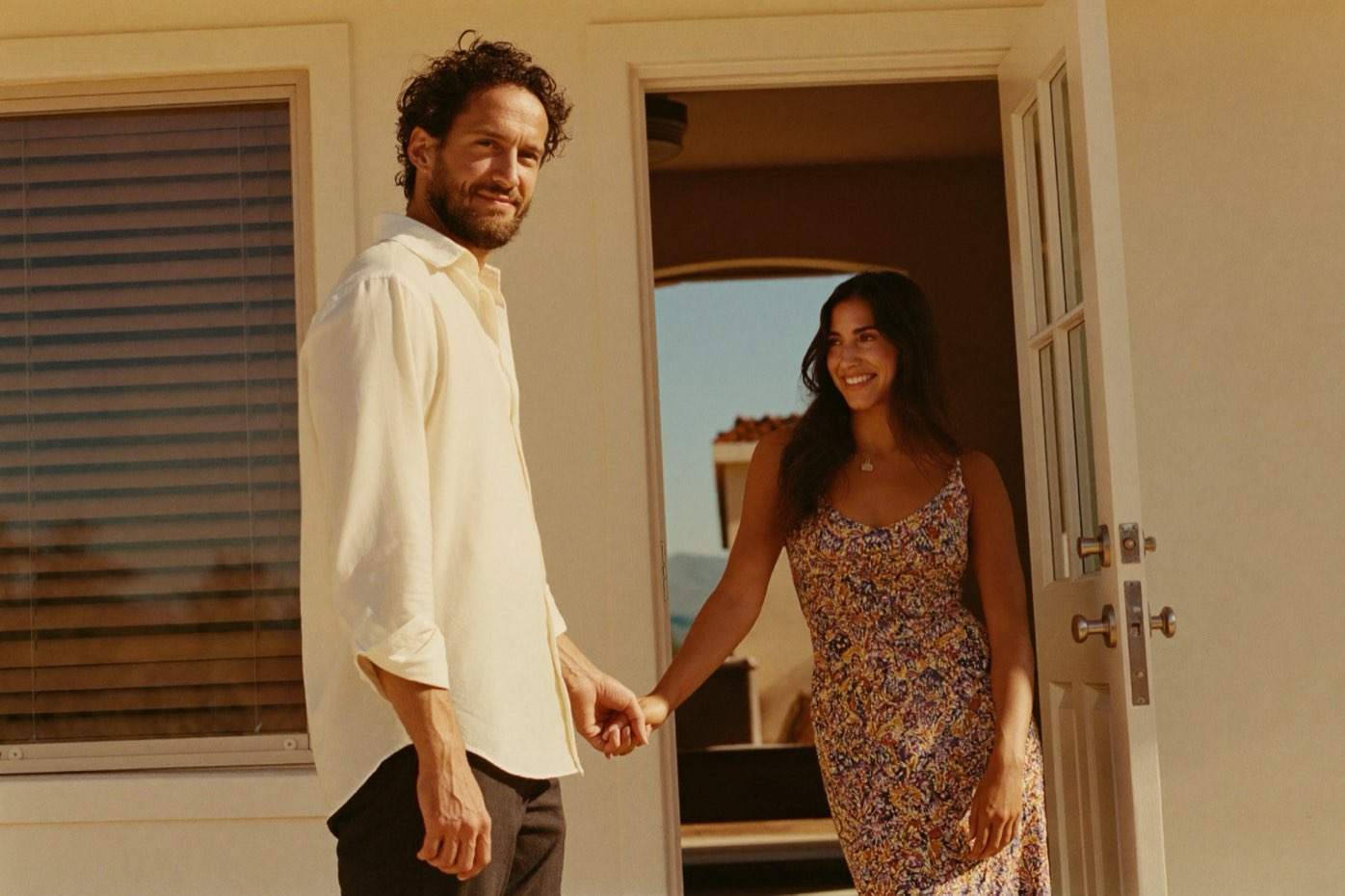 A couple at the front door of a home, keys in hand